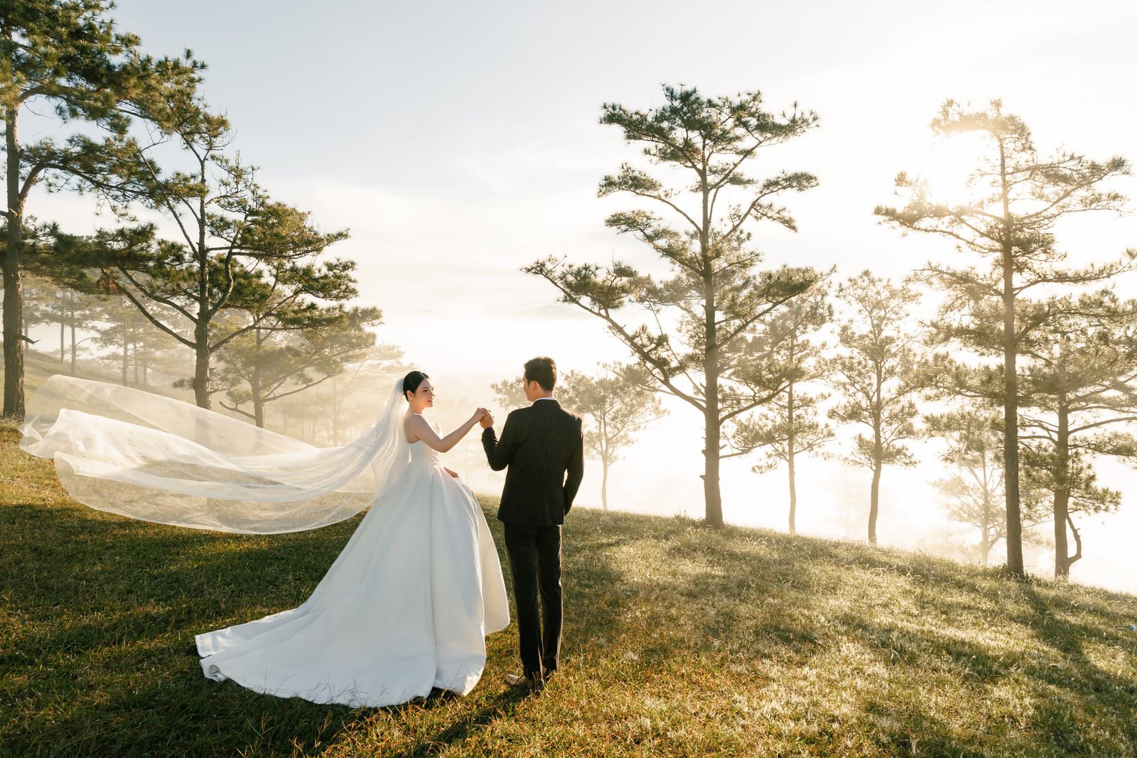 A couple holding hands outdoors in the mountains at sunrise