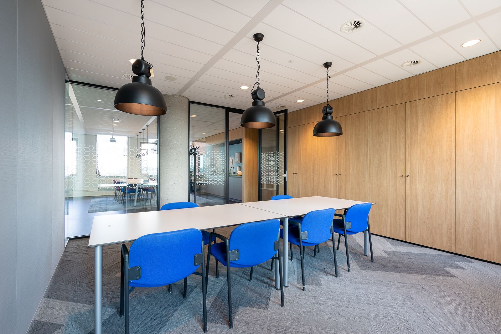 A light meeting room with windows onto trees